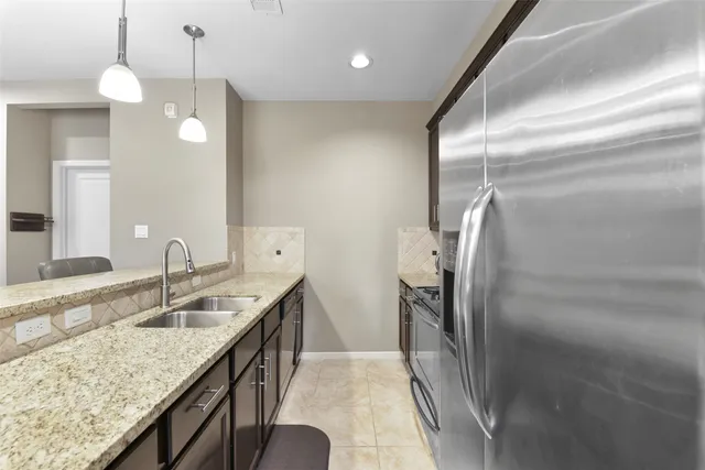 a kitchen with granite countertop a sink and refrigerator