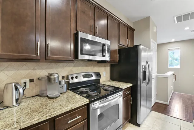 a kitchen with granite countertop stainless steel appliances and wooden cabinets