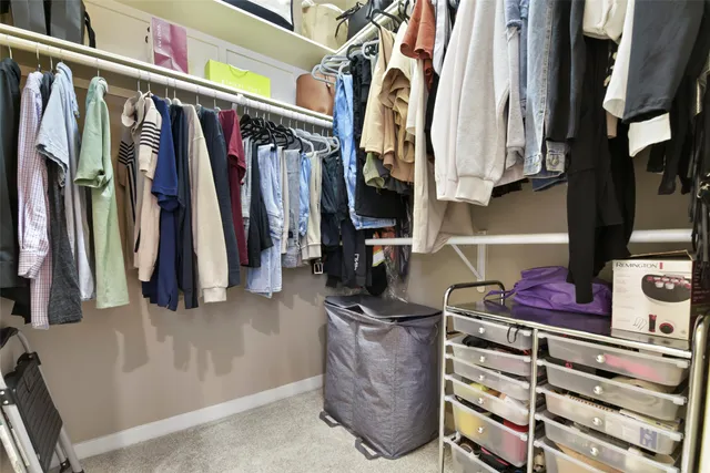a view of walk in closet with clothes and shoes
