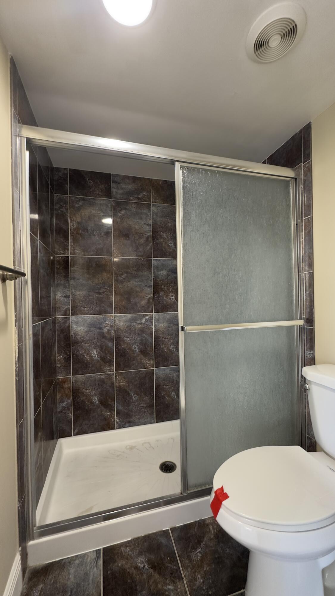 2425 Presidential Way, Unit 203 West Palm Beach, FL 33401 - Photo 17 of 35 a bathroom with a toilet and a shower