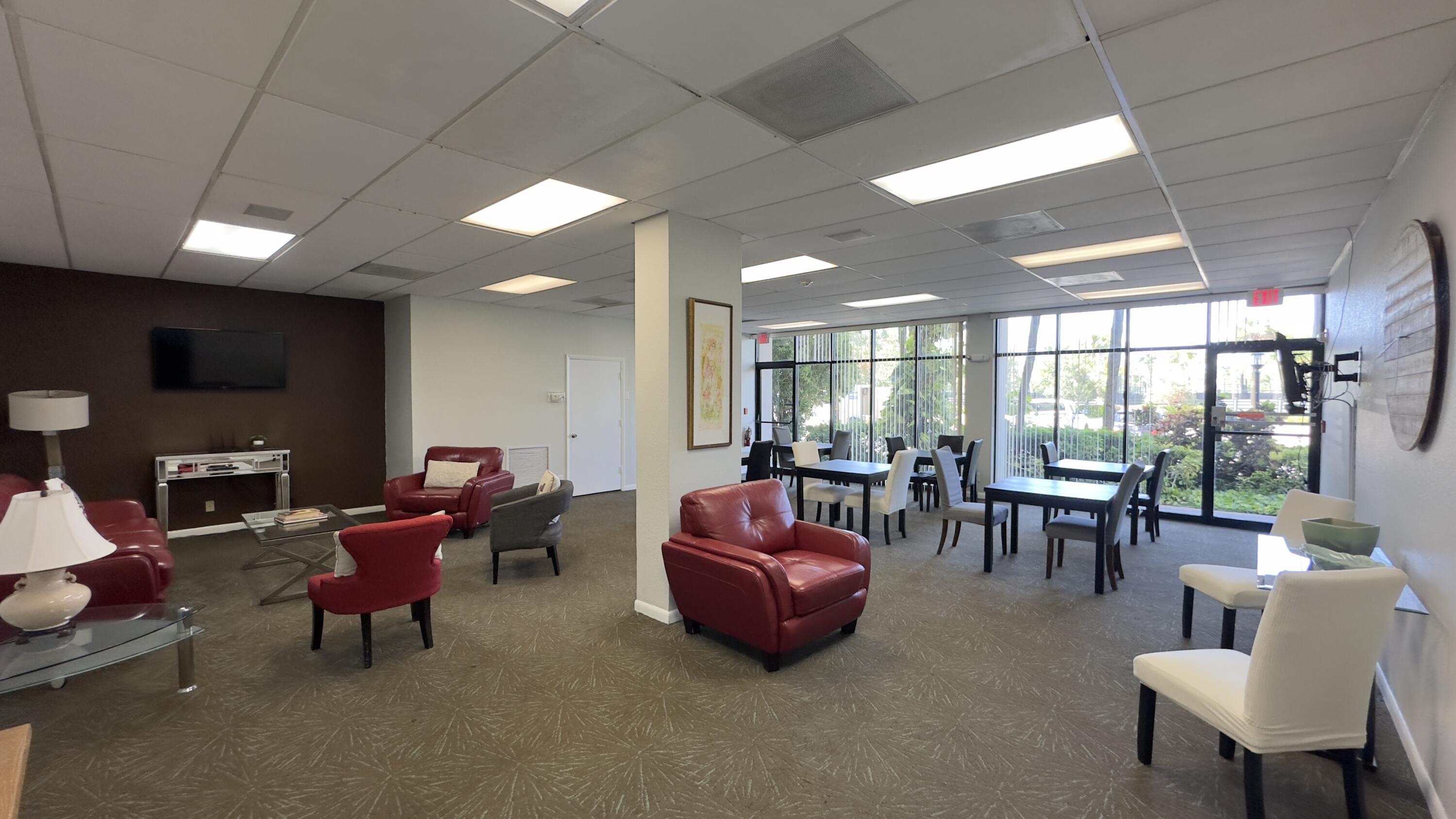 2425 Presidential Way, Unit 203 West Palm Beach, FL 33401 - Photo 29 of 35 a living room with furniture a flat screen tv and large windows