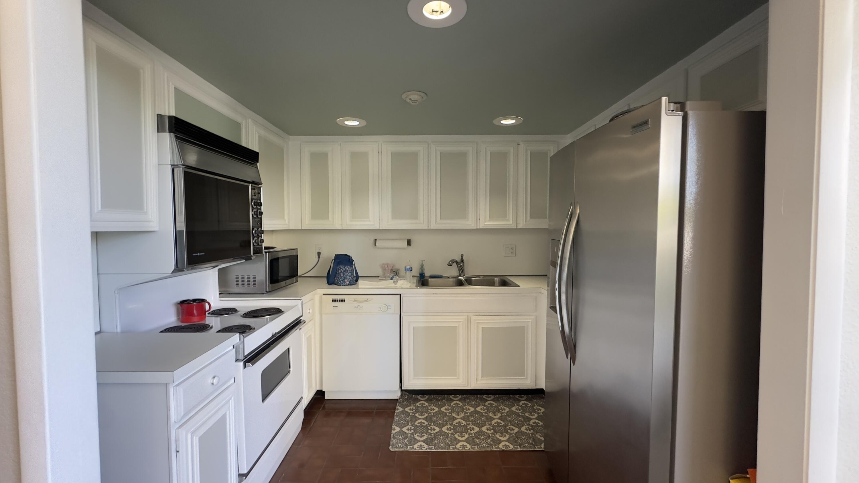 2425 Presidential Way, Unit 203 West Palm Beach, FL 33401 - Photo 31 of 35 a kitchen with a sink a stove and cabinets