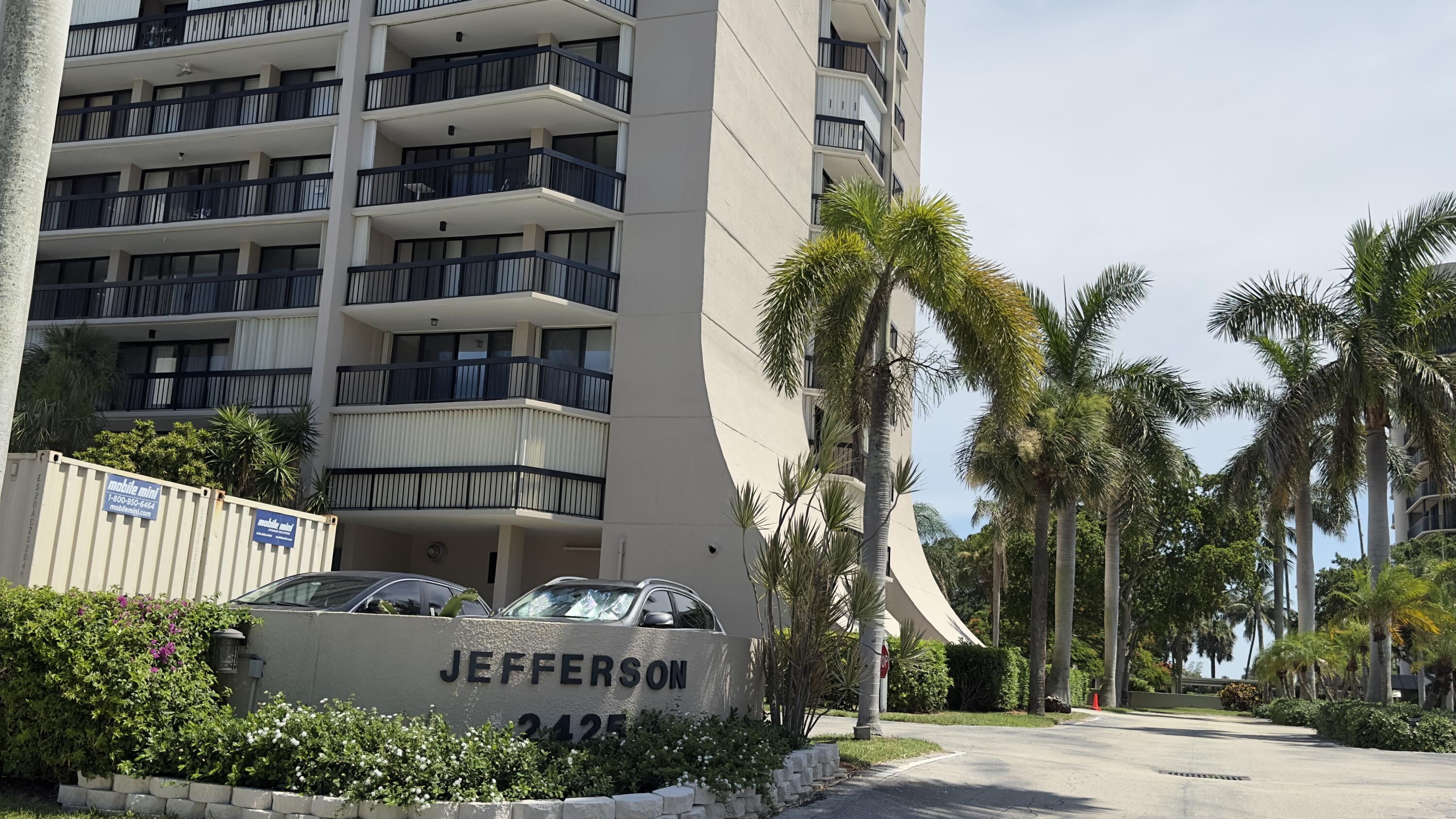 2425 Presidential Way, Unit 203 West Palm Beach, FL 33401 - Photo 34 of 35 a front view of multi story residential apartment building with yard and sign board