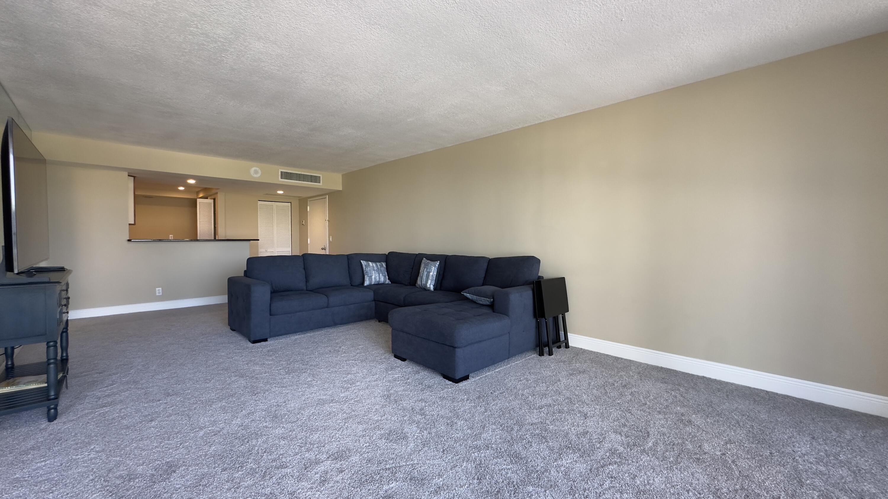 2425 Presidential Way, Unit 203 West Palm Beach, FL 33401 - Photo 7 of 35 a living room with a couch and a table