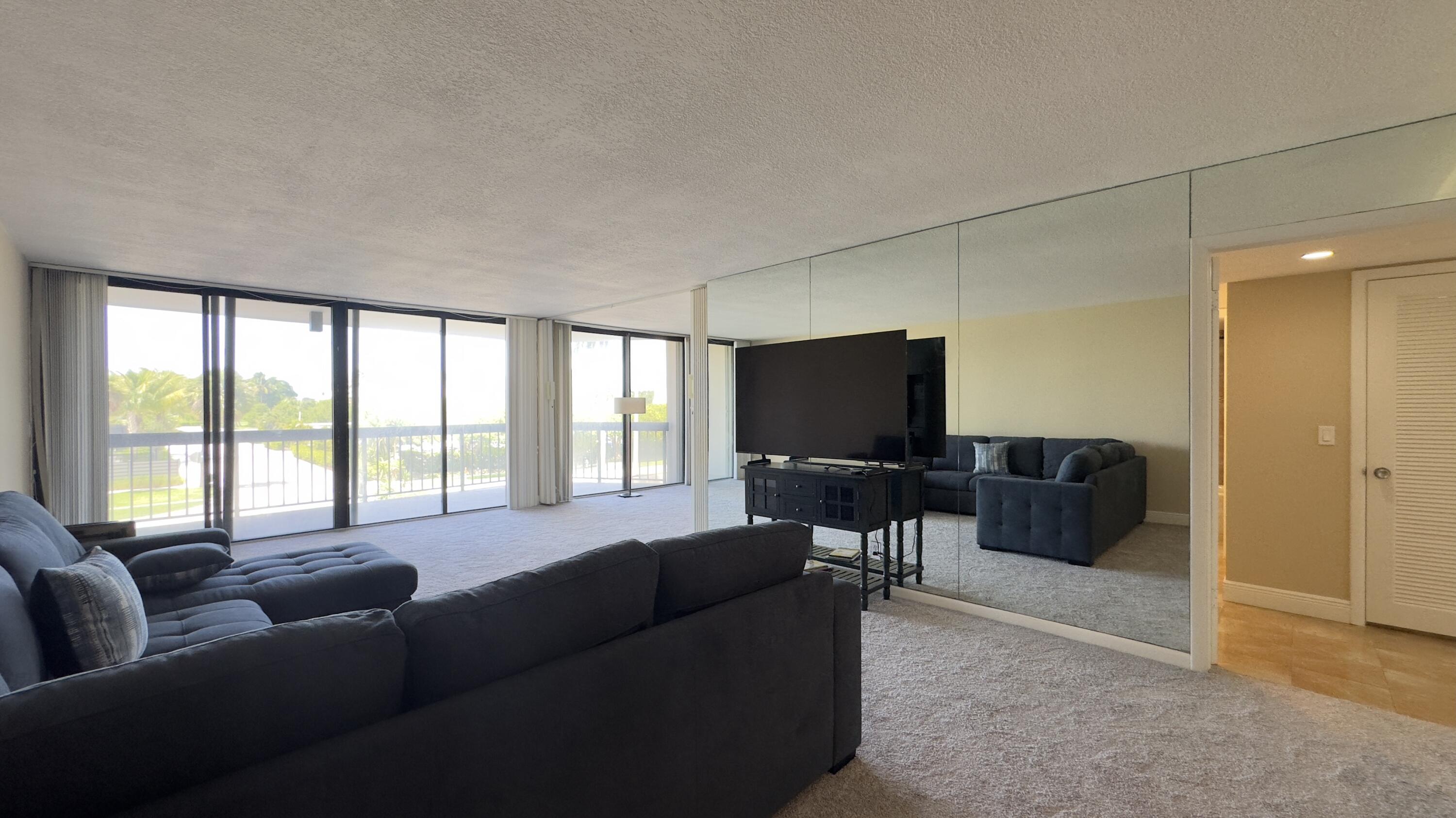 2425 Presidential Way, Unit 203 West Palm Beach, FL 33401 - Photo 8 of 35 a living room with furniture and a flat screen tv