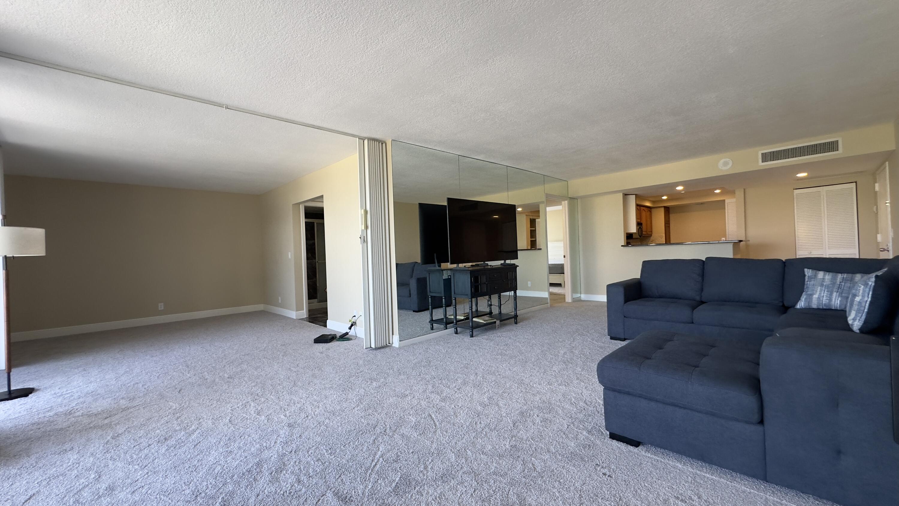 2425 Presidential Way, Unit 203 West Palm Beach, FL 33401 - Photo 9 of 35 a living room with furniture and a flat screen tv
