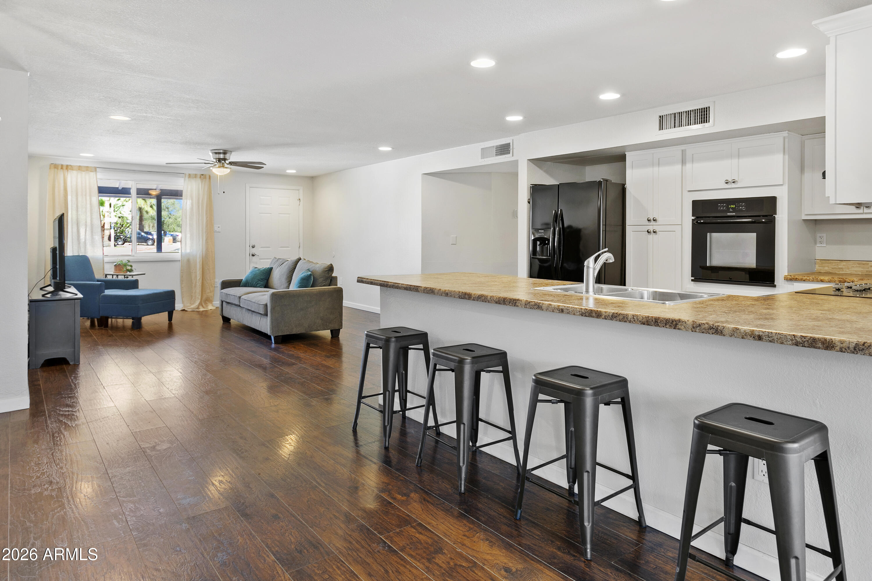 3445 East Thunderbird Road Phoenix, AZ 85032 - Photo 13 of 35 a large white kitchen with granite countertop a stove a sink a table and chairs