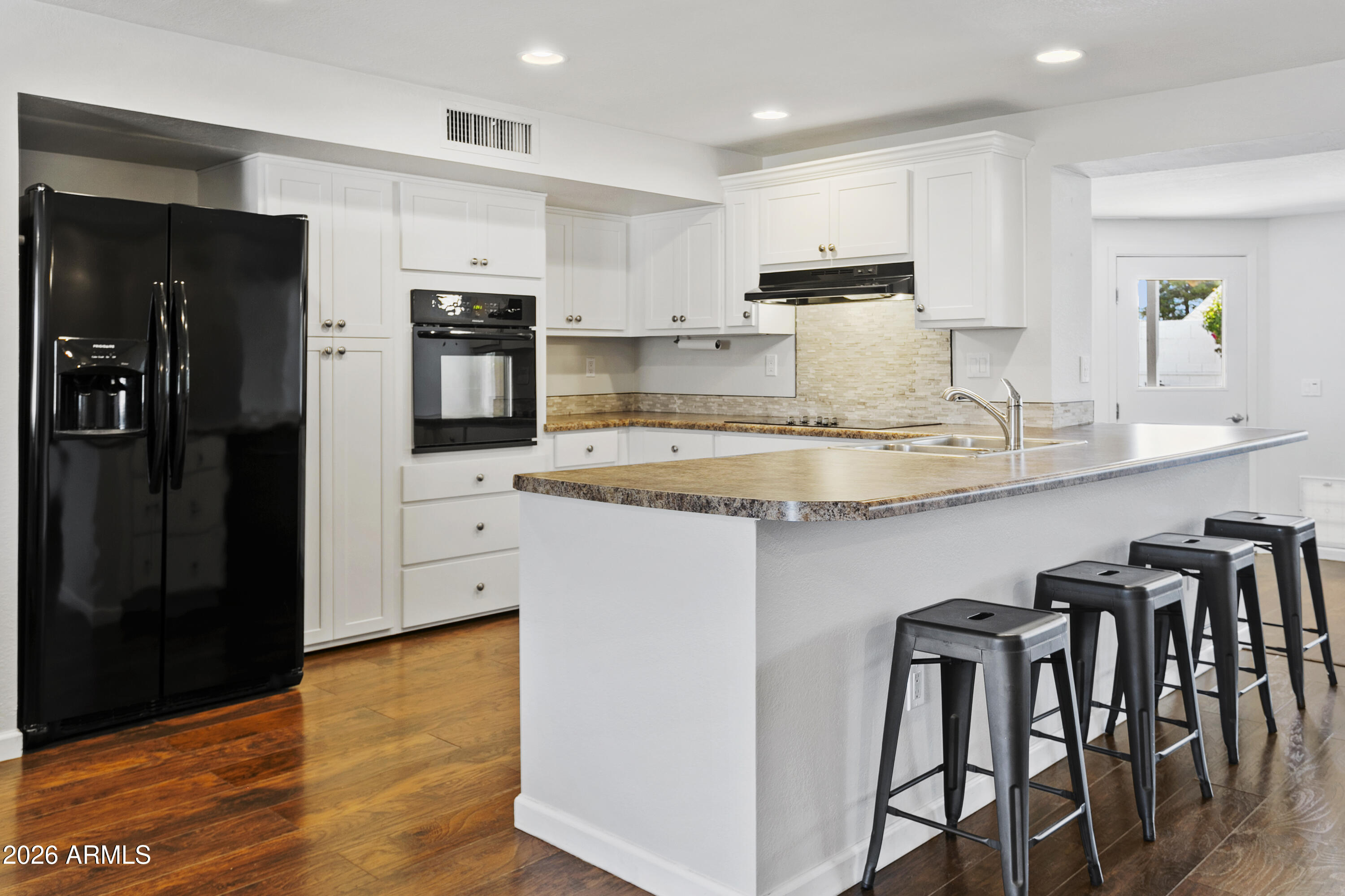 3445 East Thunderbird Road Phoenix, AZ 85032 - Photo 8 of 35 a kitchen with kitchen island granite countertop a table chairs refrigerator and microwave