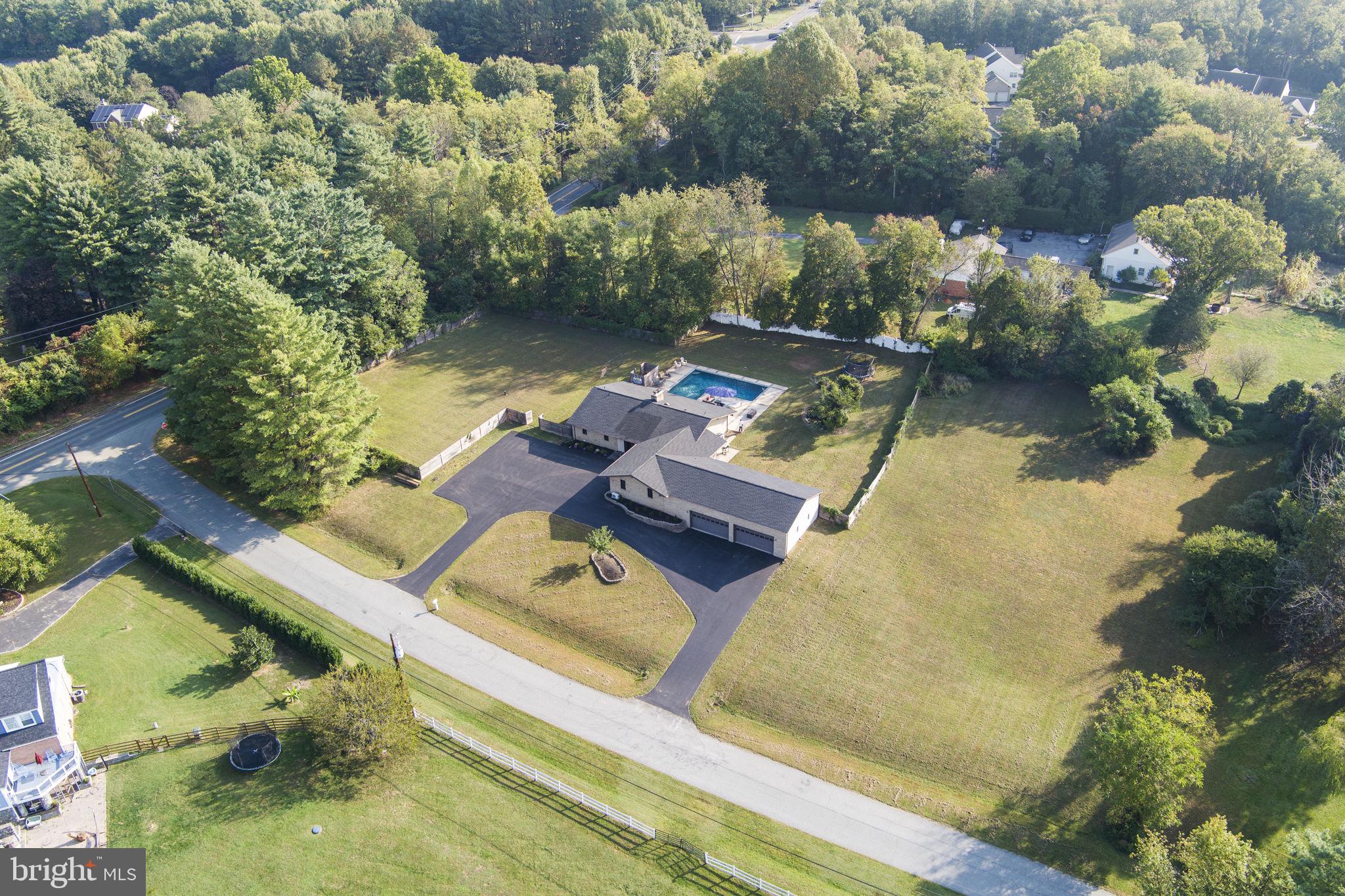 an aerial view of a house with swimming pool and lake view