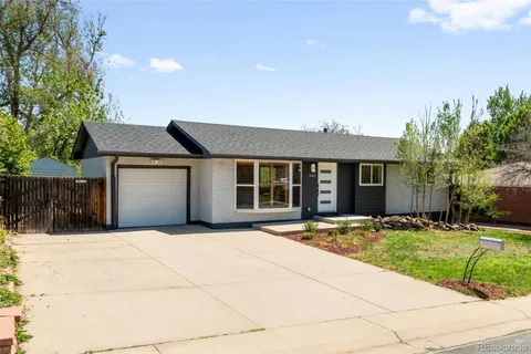 a front view of a house with a yard and potted plants
