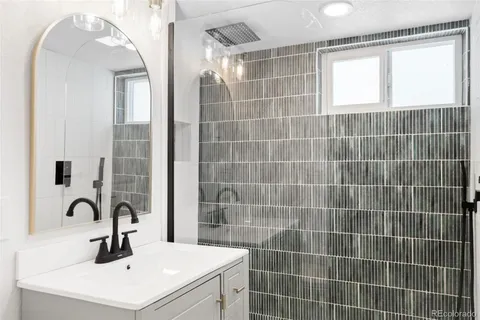a bathroom with a sink a shower and a mirror