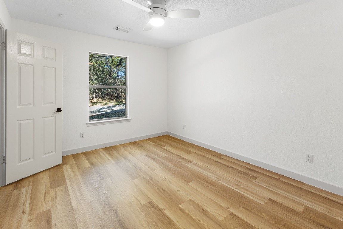 520 Hunter Ridge Road San Marcos, TX 78666 - Photo 16 of 27 an empty room with wooden floor and windows