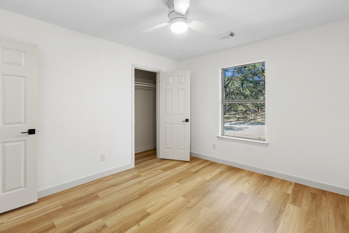 520 Hunter Ridge Road San Marcos, TX 78666 - Photo 17 of 27 a view of an empty room with wooden floor and a window