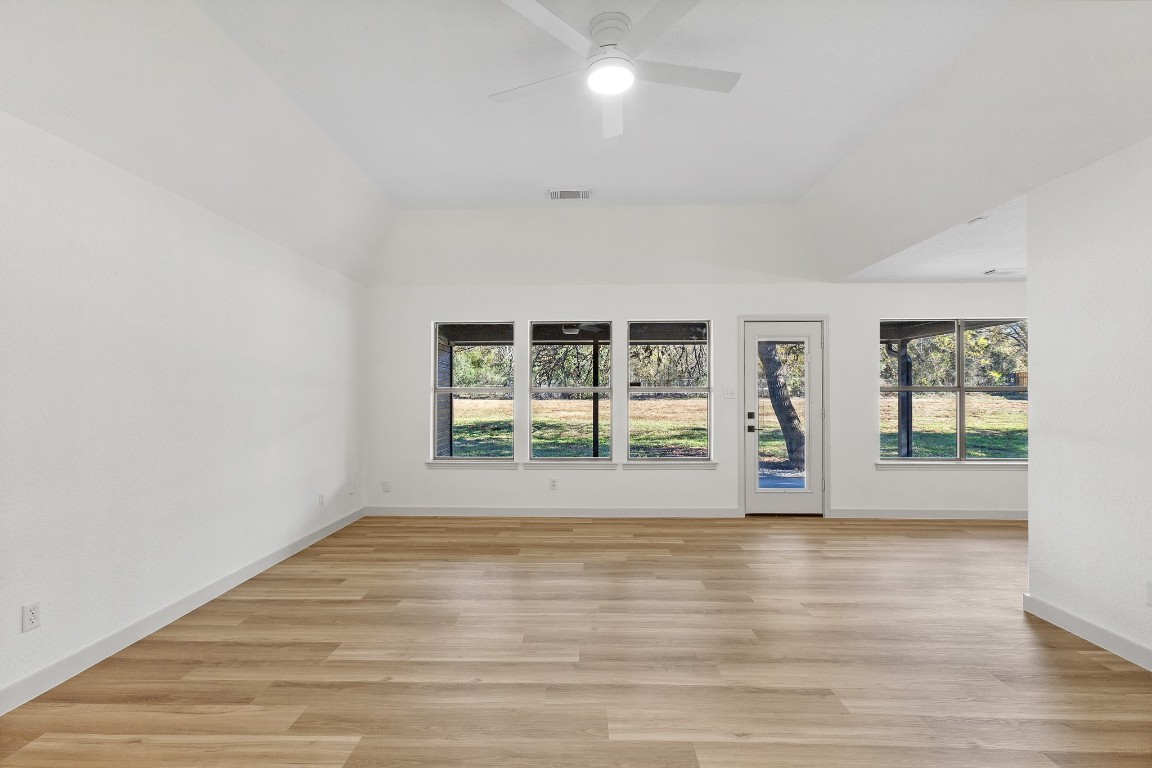 520 Hunter Ridge Road San Marcos, TX 78666 - Photo 3 of 27 a view of an empty room with wooden floor and a window