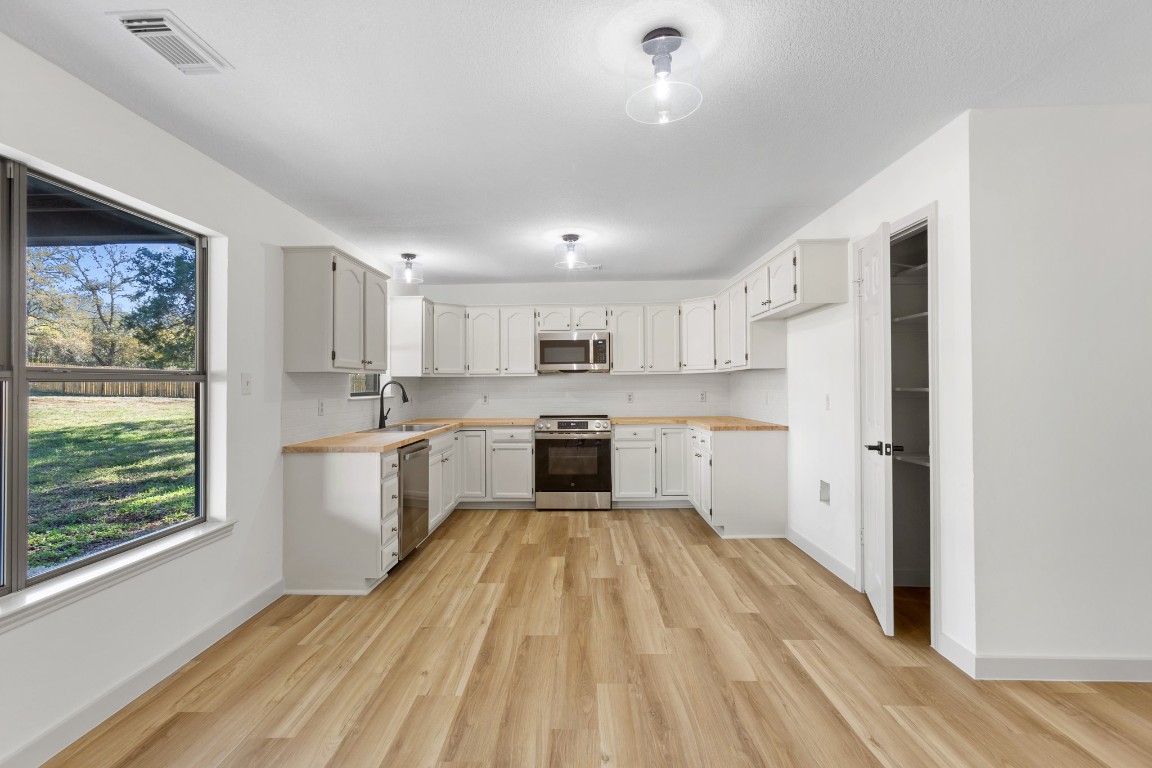 520 Hunter Ridge Road San Marcos, TX 78666 - Photo 5 of 27 a large kitchen with a white stove top oven and white cabinets