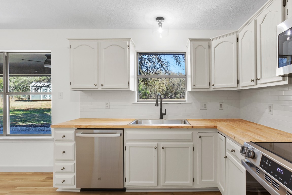 520 Hunter Ridge Road San Marcos, TX 78666 - Photo 6 of 27 a kitchen with white cabinets and a window