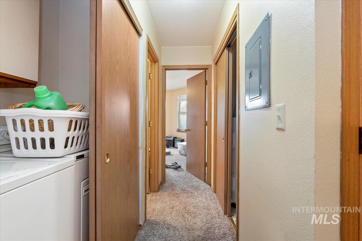 33 South Mike Street Boise, ID 83705 - Photo 31 of 50 Hallway with light carpet, electric panel, and separate washer and dryer