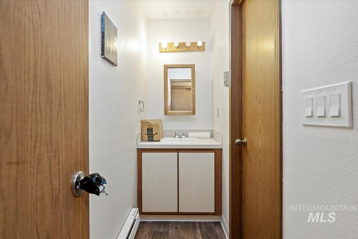 33 South Mike Street Boise, ID 83705 - Photo 37 of 50 Bathroom featuring a textured wall, vanity, a baseboard radiator, and dark wood-style floors