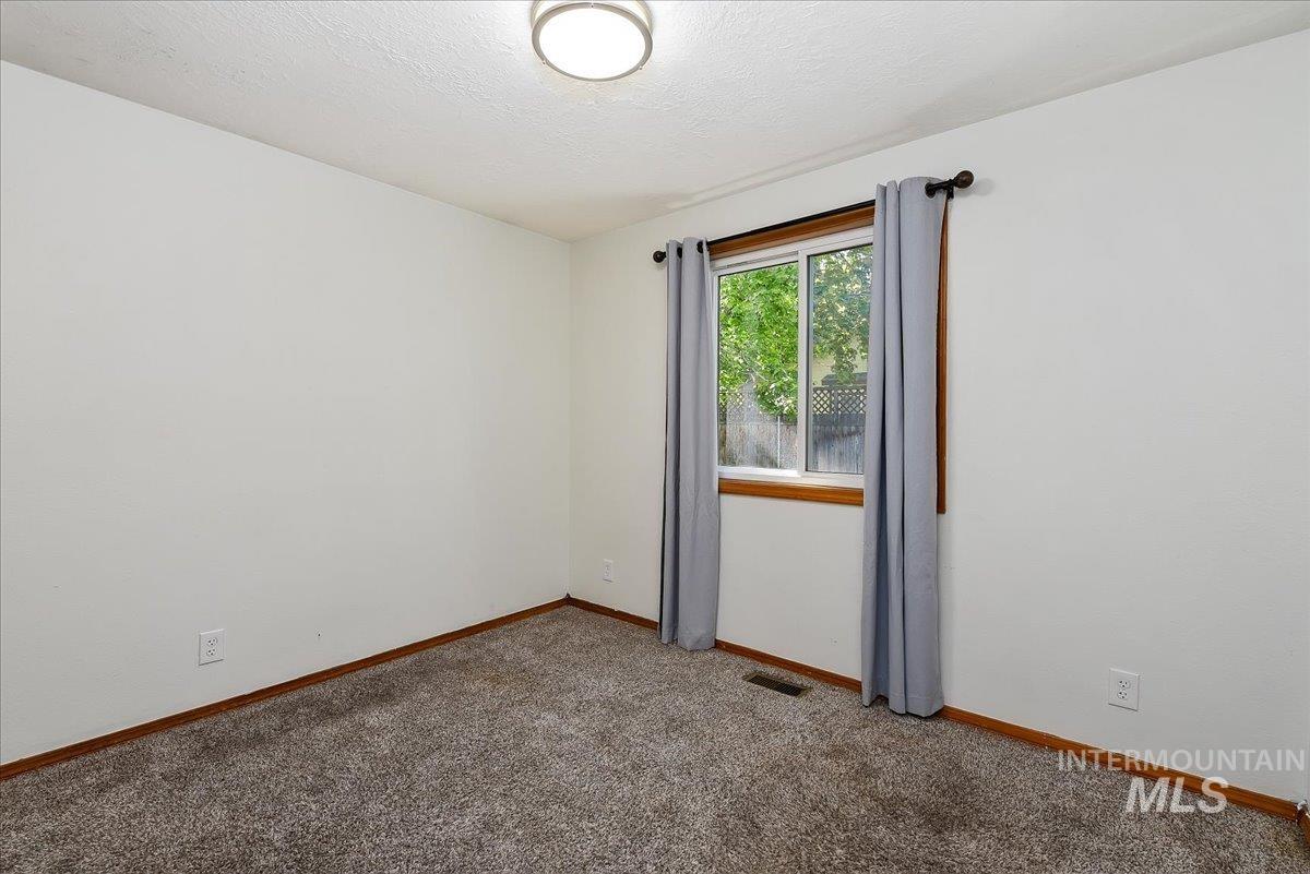9215 West Preece Street Boise, ID 83704 - Photo 9 of 22 Windowed room featuring textured carpet flooring and a ceiling-mounted light fixture