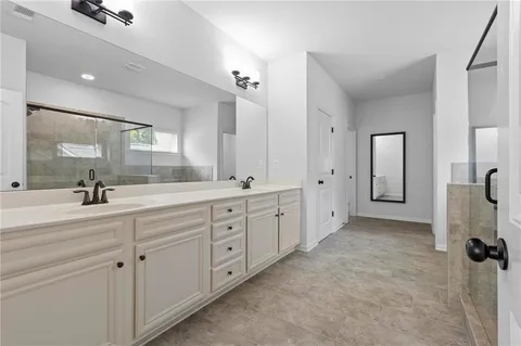 a spacious bathroom with a double vanity sink mirror and shower