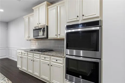 a kitchen with granite countertop white cabinets stainless steel appliances and sink