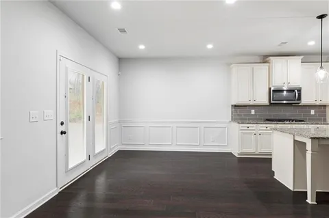 a view of a kitchen with granite countertop cabinets and wooden floor