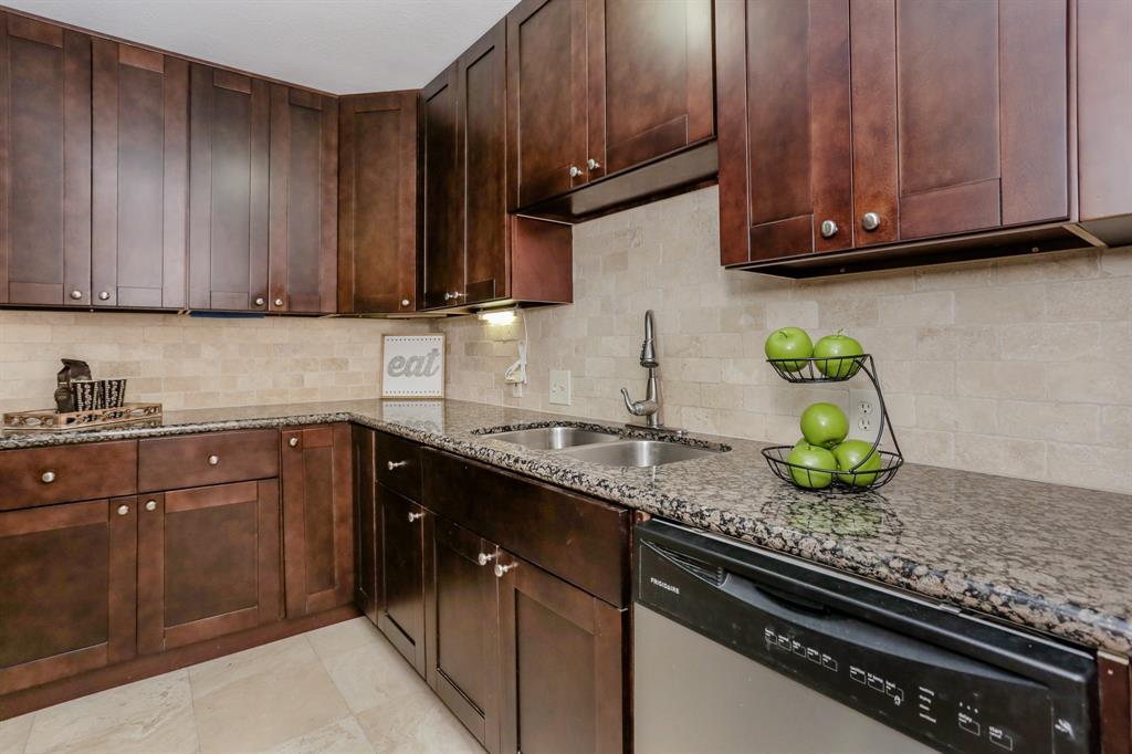 a kitchen with granite countertop wooden cabinets stainless steel appliances and a sink