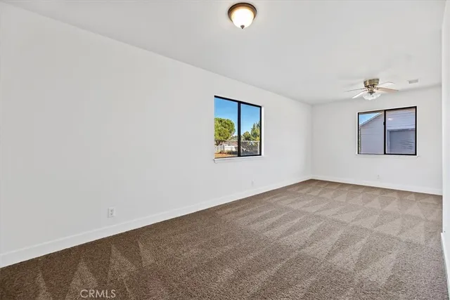 an empty room with windows and mirror