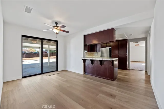a view of kitchen with stainless steel appliances kitchen island a stove a refrigerator a sink dishwasher with wooden cabinets and glass door