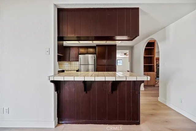 a view of kitchen with wooden floor and cabinets