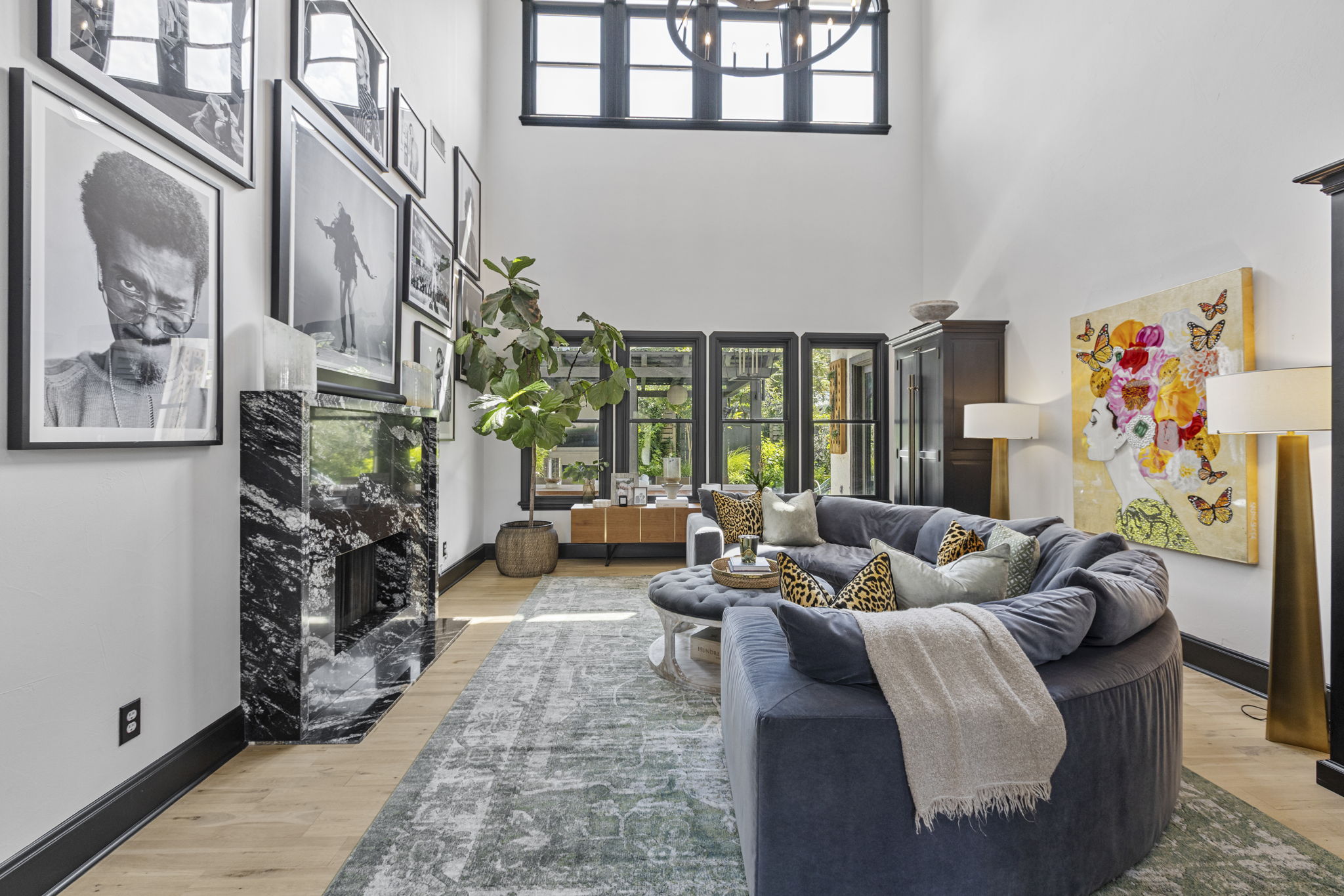 2621 Exposition Boulevard Austin, TX 78703 - Photo 6 of 30 Living room with healthy amount of natural light, light wood-style flooring, a premium fireplace, a towering ceiling, and a chandelier