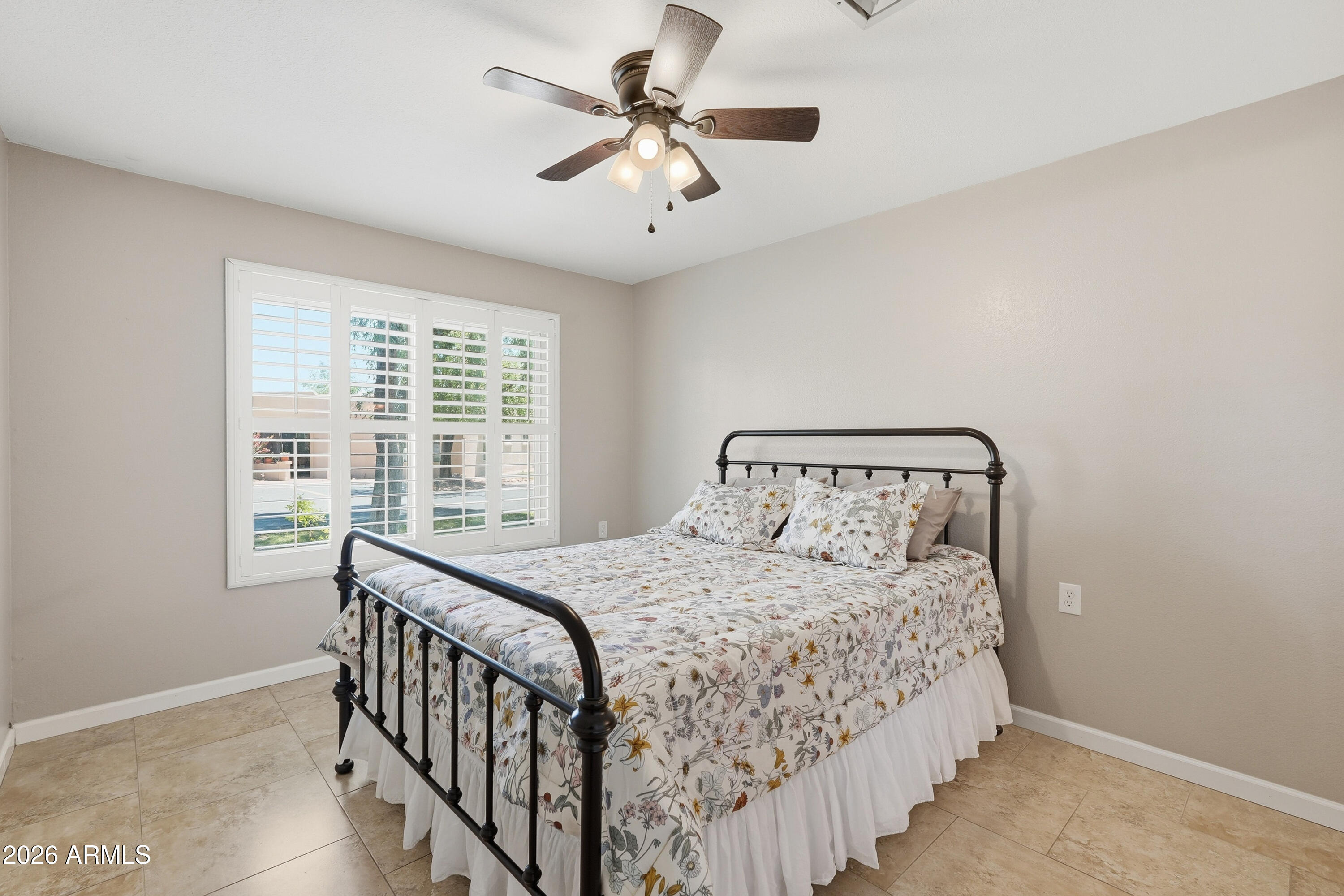 14300 West Bell Road, Unit 49 Surprise, AZ 85374 - Photo 8 of 19 a bedroom with a bed and a chandelier