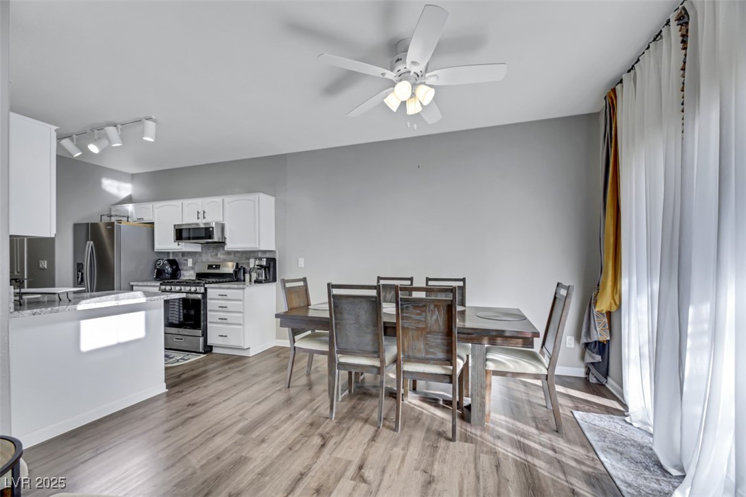 2907 Rio Sonora Court Henderson, NV 89074 - Photo 8 of 35 Dining area with light wood-type flooring, a ceiling fan, and rail lighting