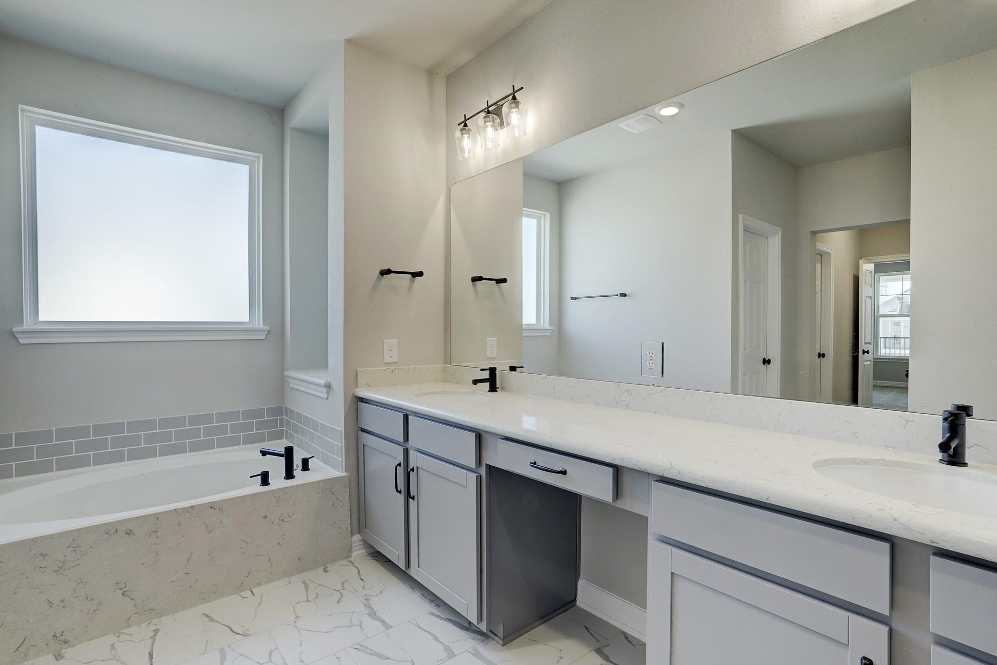 9522 Caddo Ridge Lane Cypress, TX 77433 - Photo 18 of 38 a bathroom with a tub sink and mirror