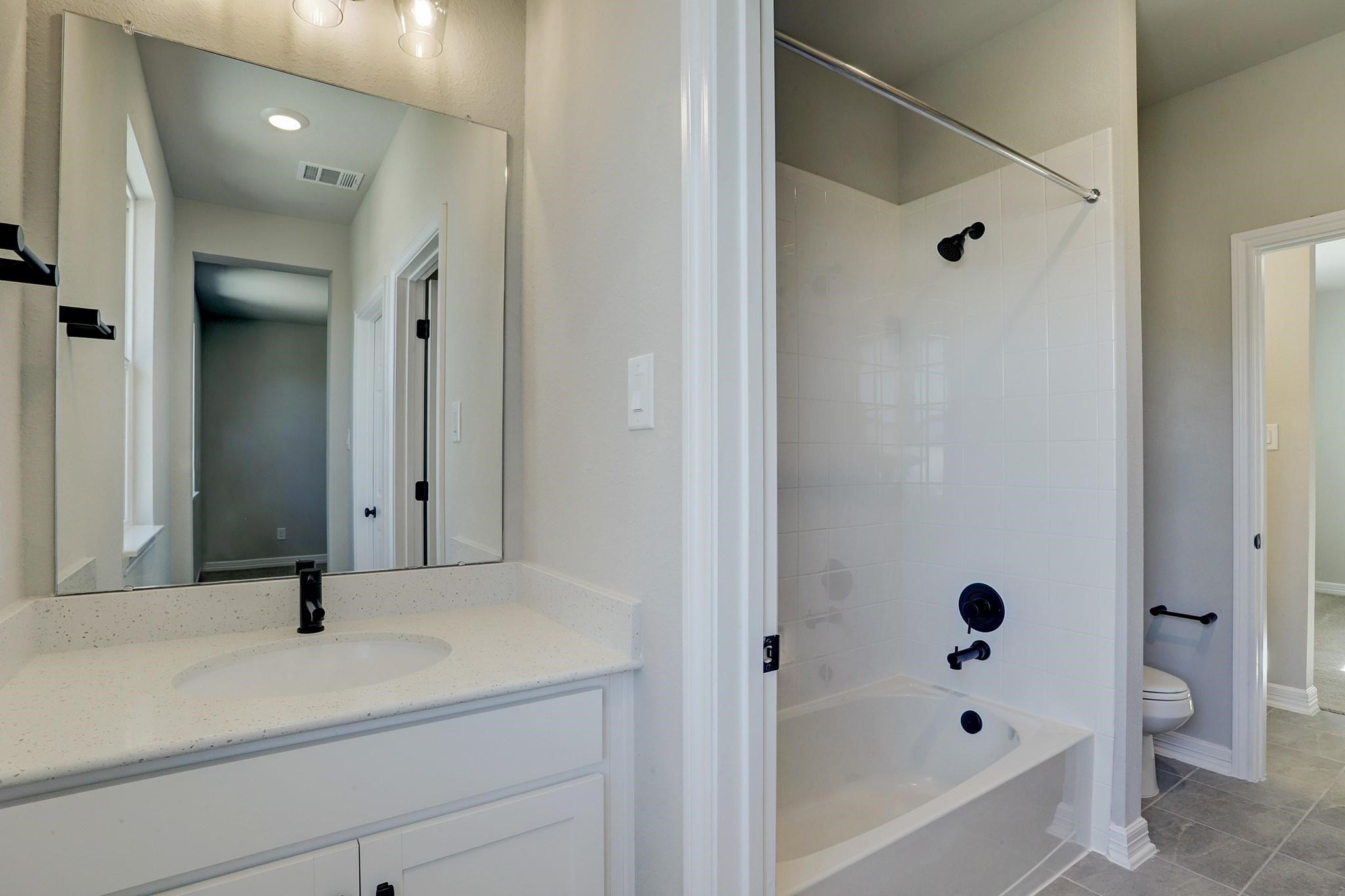 9522 Caddo Ridge Lane Cypress, TX 77433 - Photo 25 of 38 a bathroom with a tub shower vanity and a sink