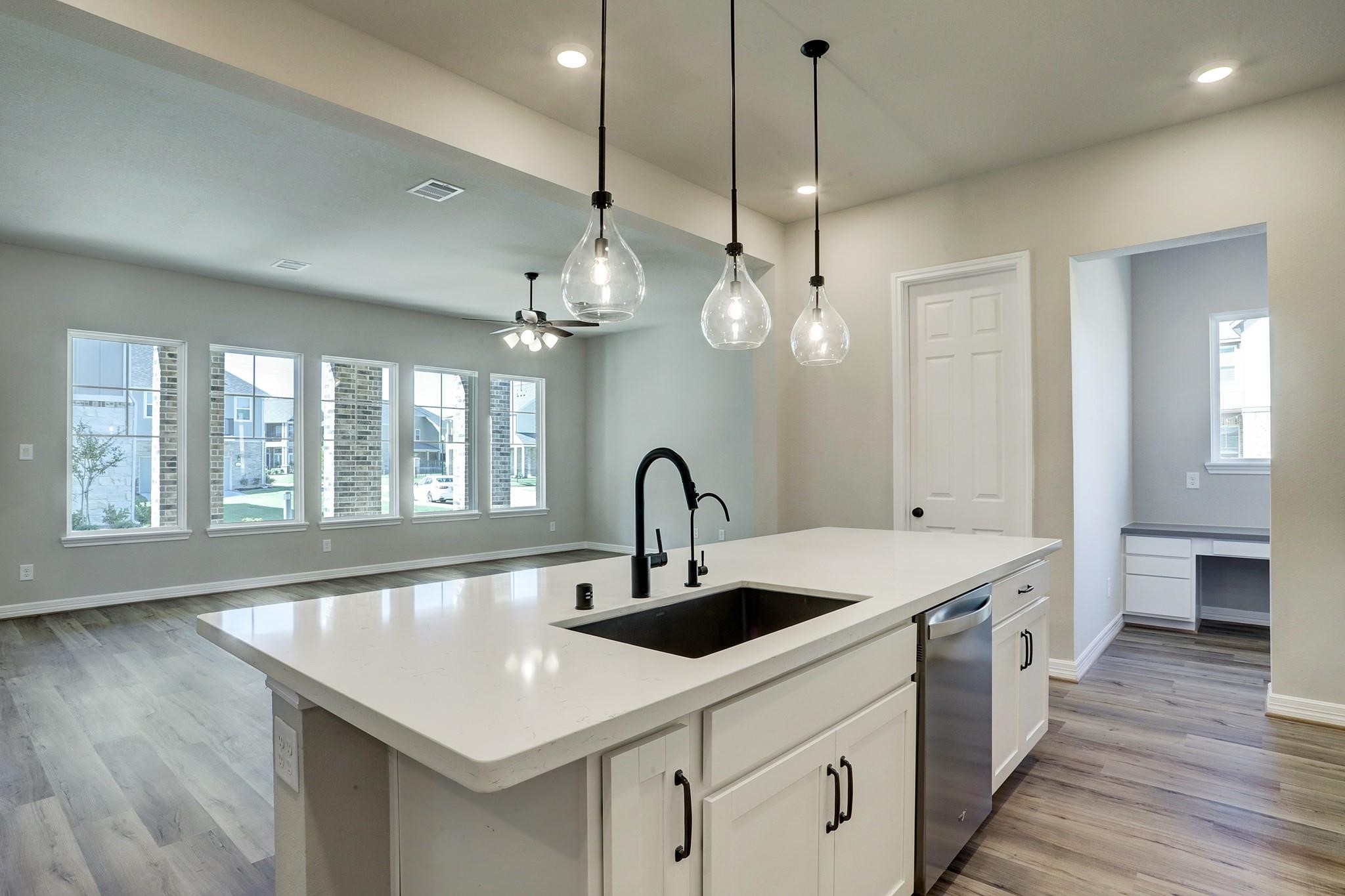 9522 Caddo Ridge Lane Cypress, TX 77433 - Photo 9 of 38 a kitchen with a sink and chandelier