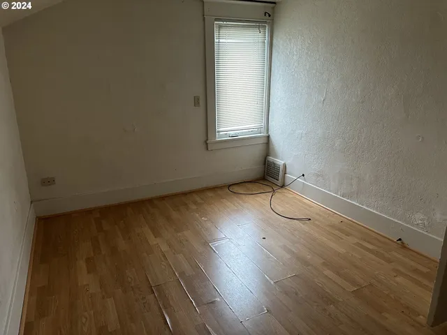 a view of a room with wooden floor and windows