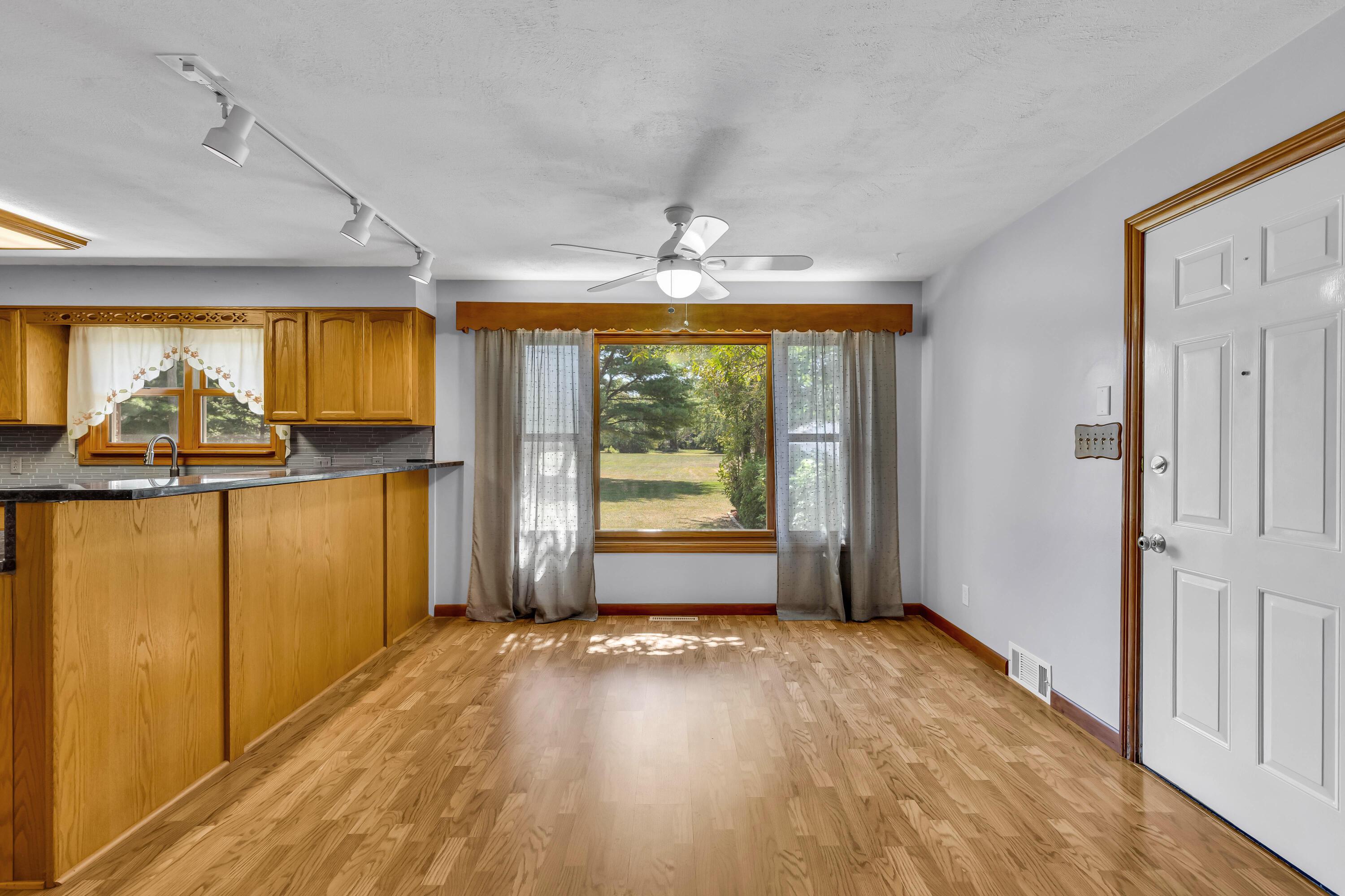 1213 East Cooke Road Columbus, OH 43224 - Photo 15 of 57 • Laminate flooring • Tan painted walls • Lighted ceiling fan • Corner wall shelf