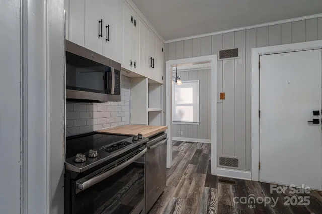 a kitchen with stainless steel appliances granite countertop a refrigerator and a stove