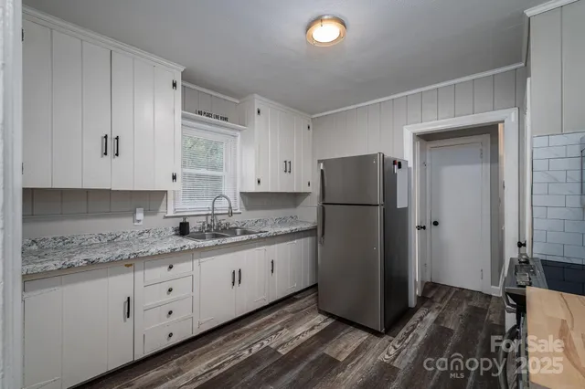 a kitchen with white cabinets and stainless steel appliances