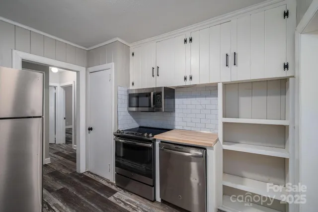 a view of empty room with wooden floor and fireplace