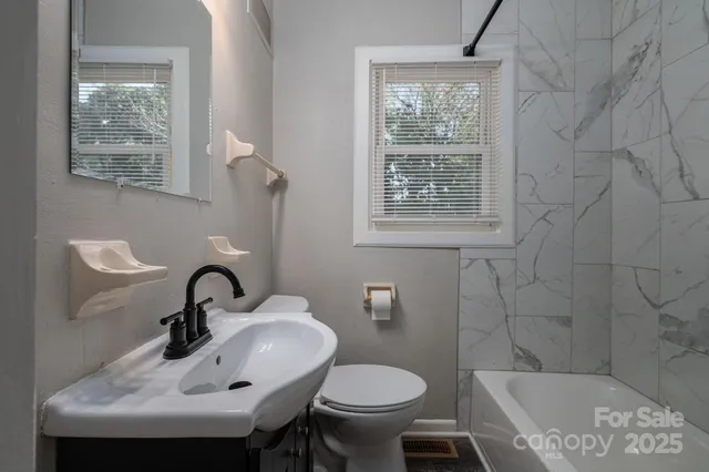 a bathroom with a toilet a sink and mirror