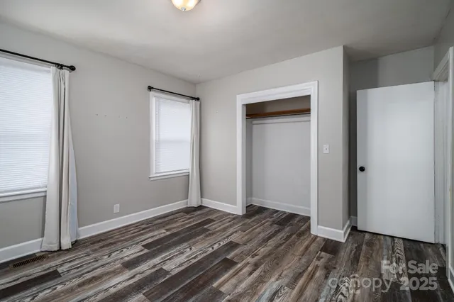 a view of a room with wooden floor and windows