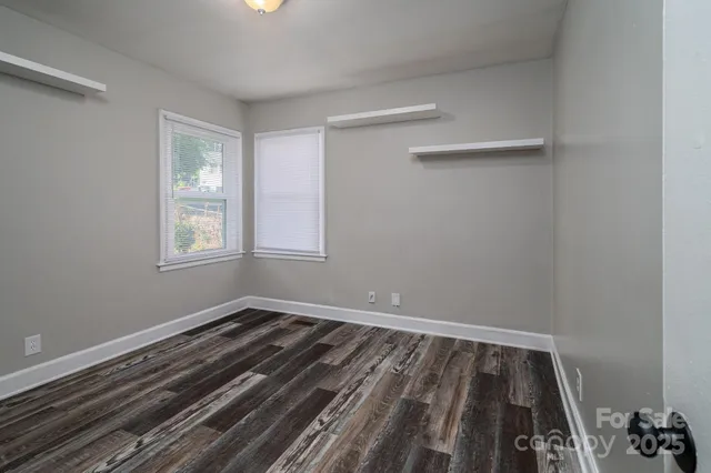 a view of a room with wooden floor and windows