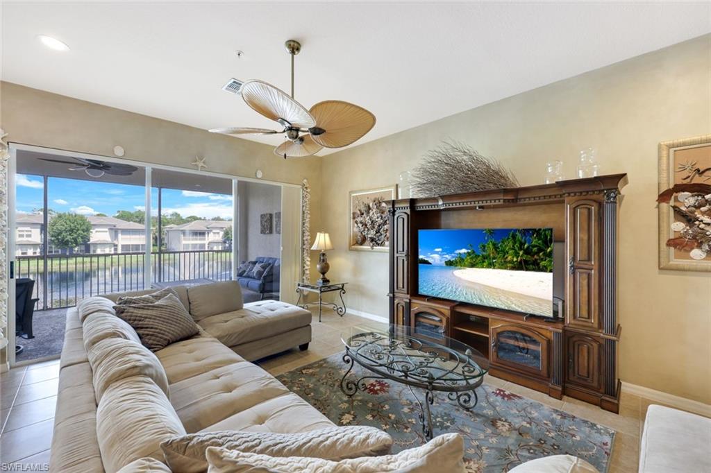 3530 Lansing Loop, Unit 202 Estero, FL 33928 - Photo 19 of 35 a living room with furniture a flat screen tv and a large window