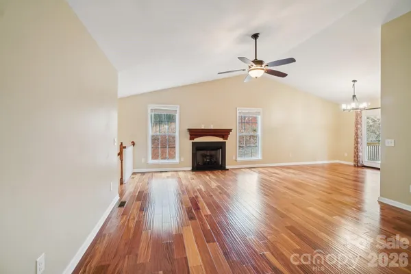 wooden floor fireplace and windows in an empty room