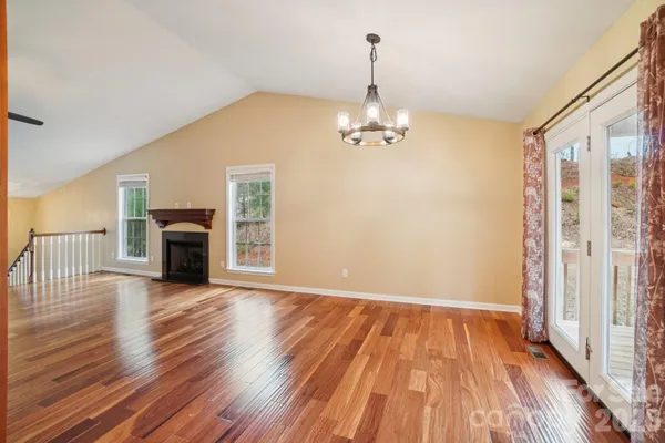 a view of empty room with wooden floor fireplace and windows
