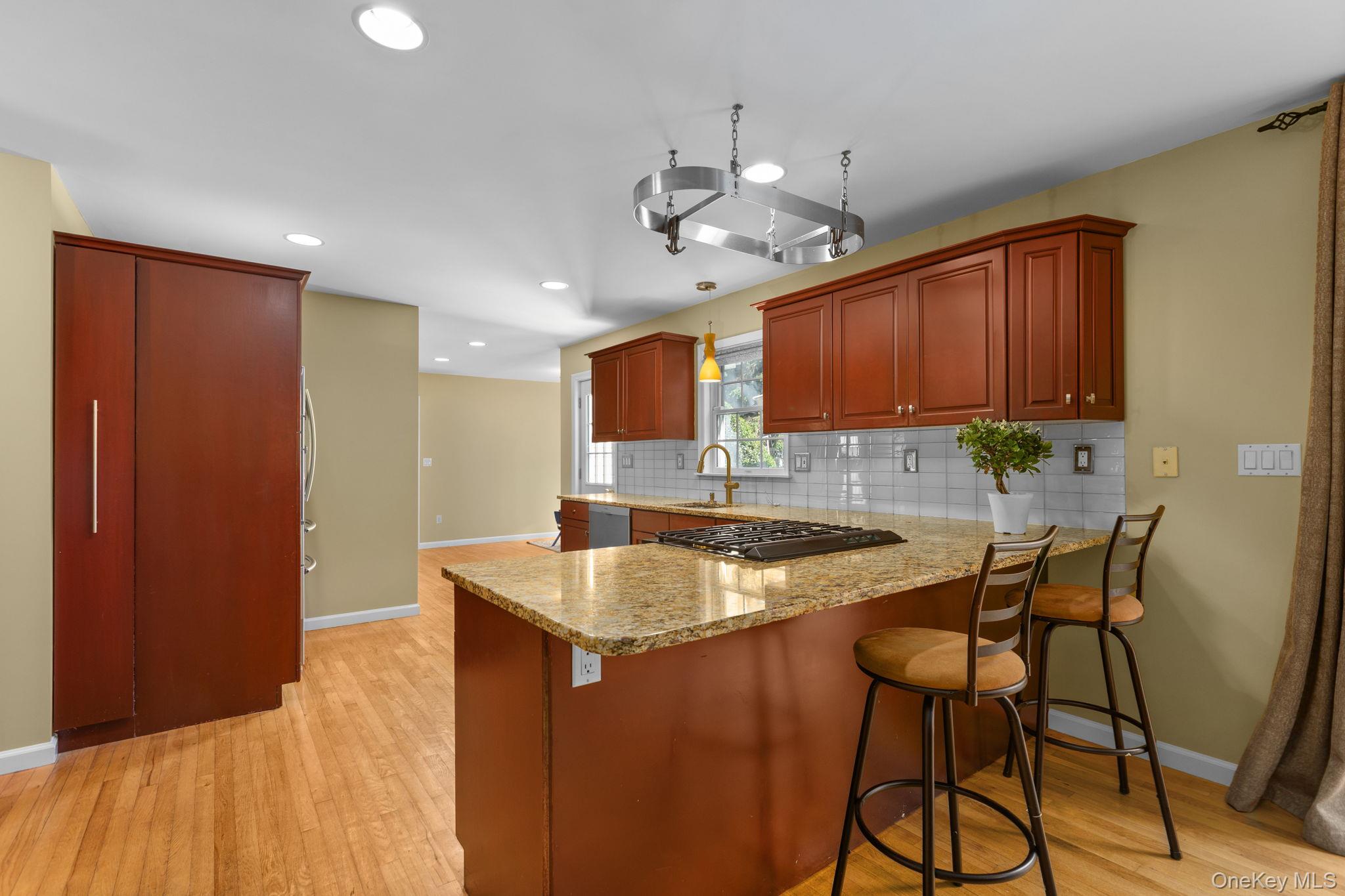 2211 Crompond Road Yorktown Heights, NY 10598 - Photo 9 of 38 a kitchen with stainless steel appliances granite countertop a sink a microwave refrigerator and chairs