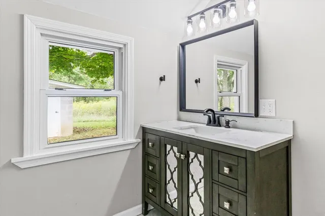 a bathroom with a sink vanity and a mirror