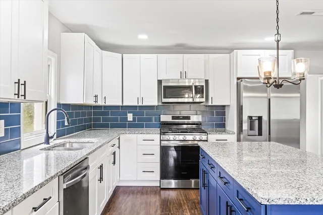 a kitchen with stainless steel appliances granite countertop a sink stove and refrigerator